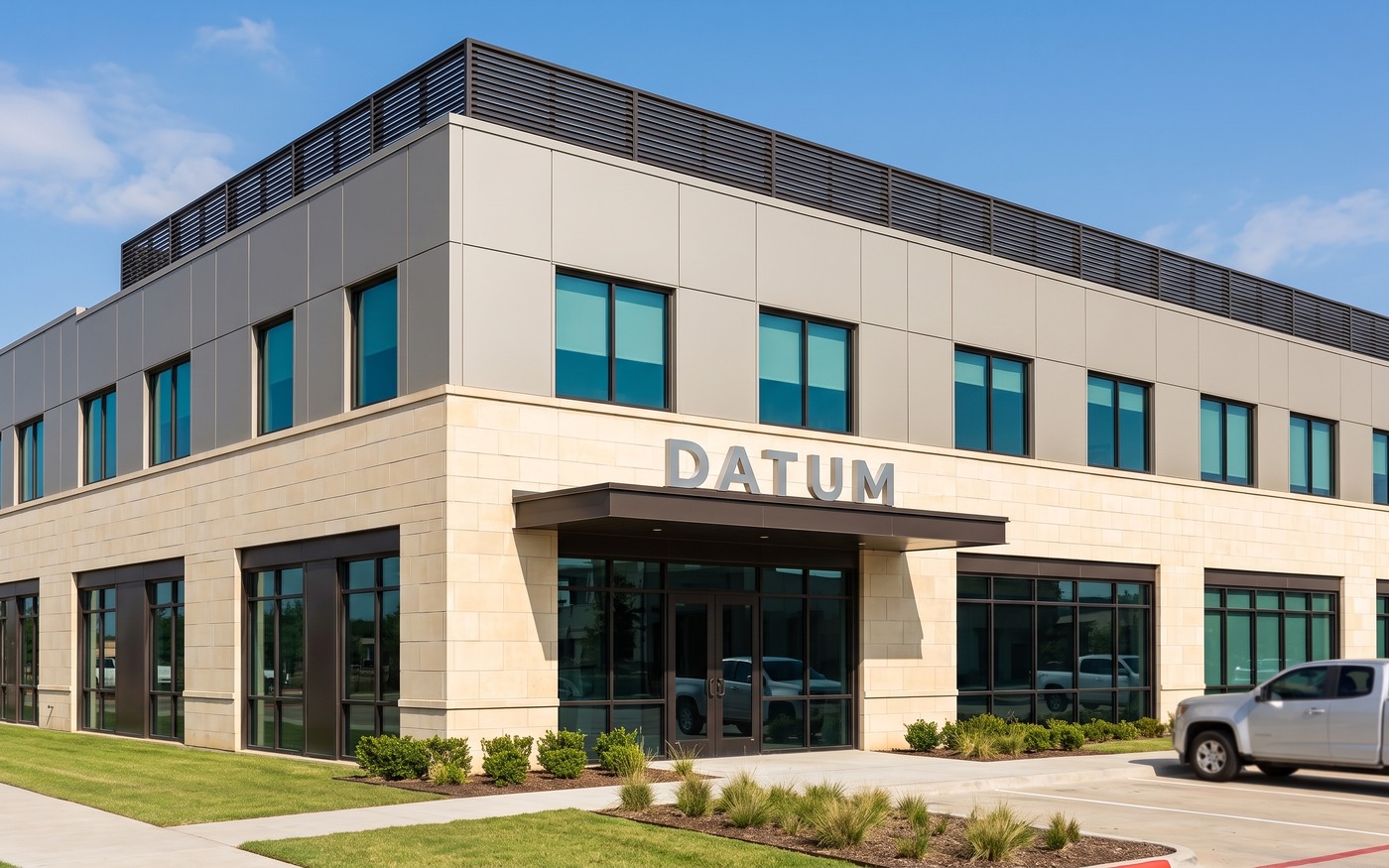 The Datum headquarters: a two storey limestone and metal panel office with DATUM in brushed steel letters above the entry canopy